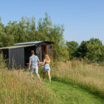 Couple walking towards their off grid shepherds hut