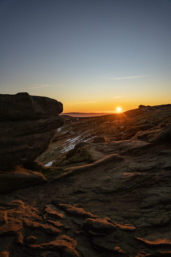 Golden sunrise glow setting on the Edale skyline on a winters day