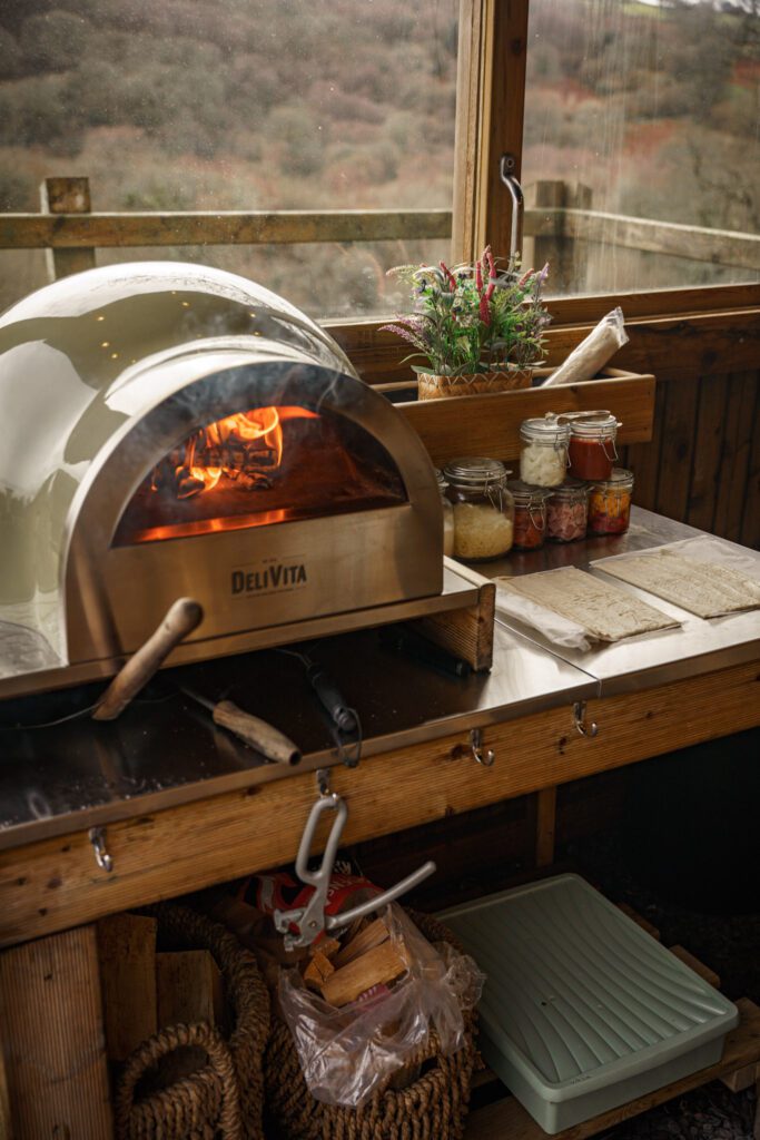 Wood fired pizza over, smoking and getting upto temperature with pizza waiting to go in