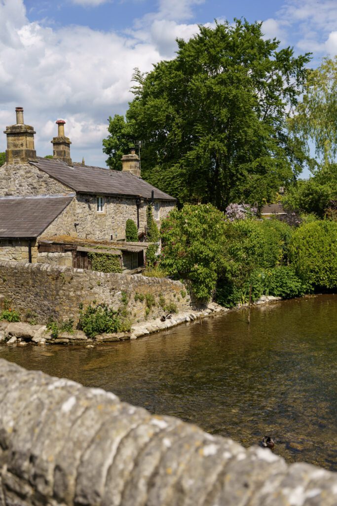 Sheepwash bridge at Ashford in the water looking towards a stone cottage