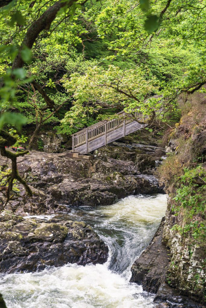 A steep bridge over the river with rushing water beneath