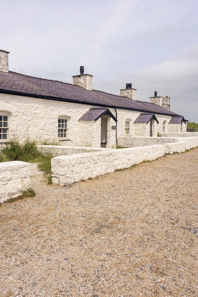 a row of one story white cottages on the beach