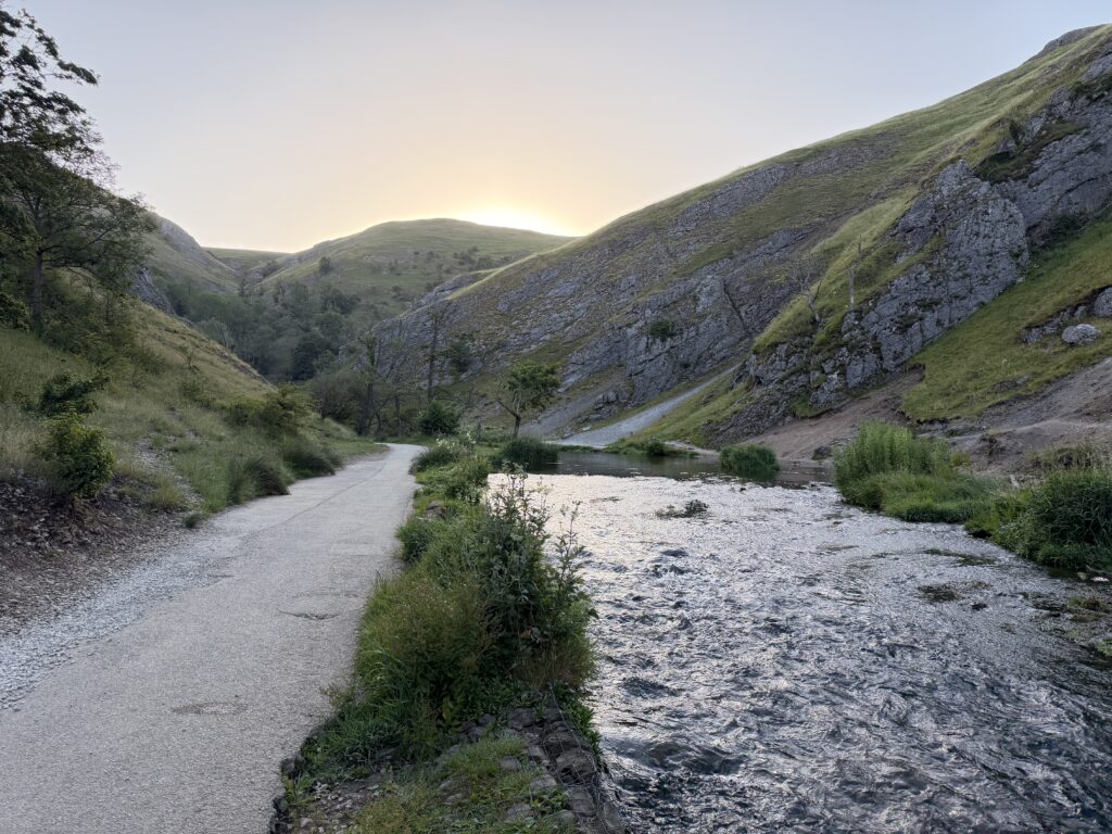 The Dovedale valley, path to the left, river to the right and the sun coming up and over the distant hills