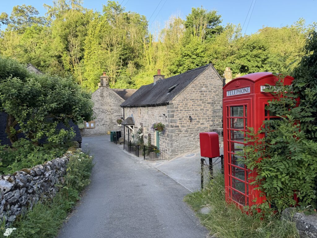 Stone cottages and a red telephone box in a picturesque Peak District Village
