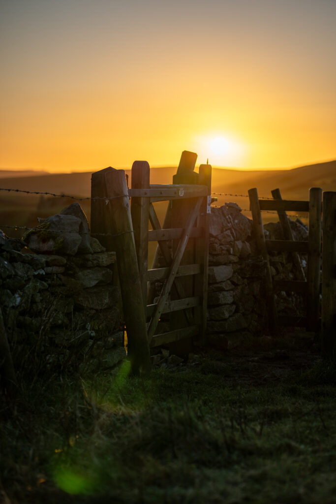 the golden sunrise glow coming up above the gate on winnats pass