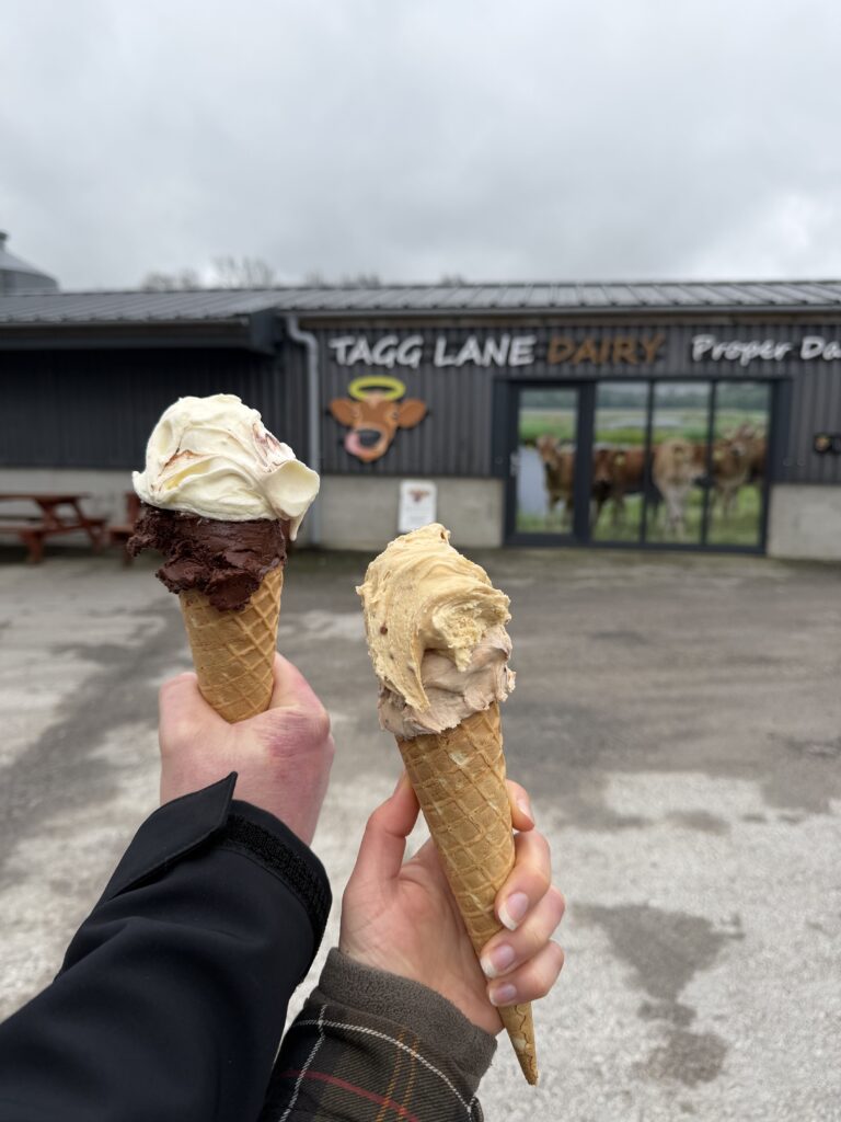 Holding 2 Ice cream cones in front of Tagg Lane Dairy