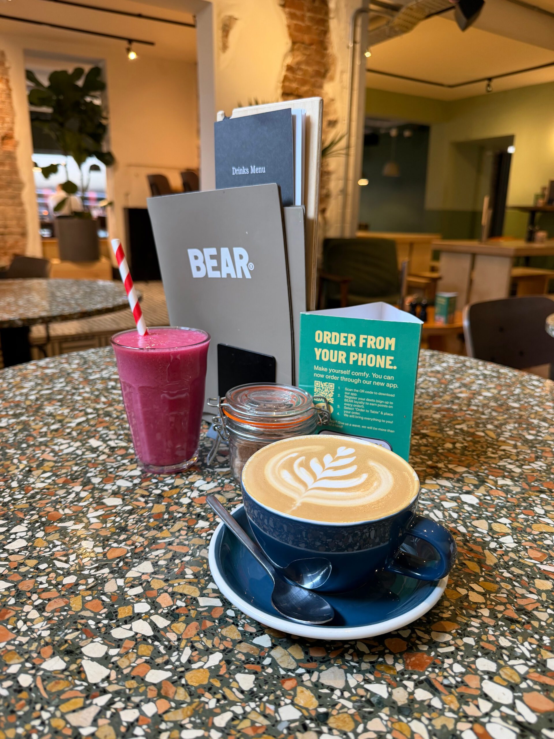 Creamy latte with coffee art and vibrant purple smoothie