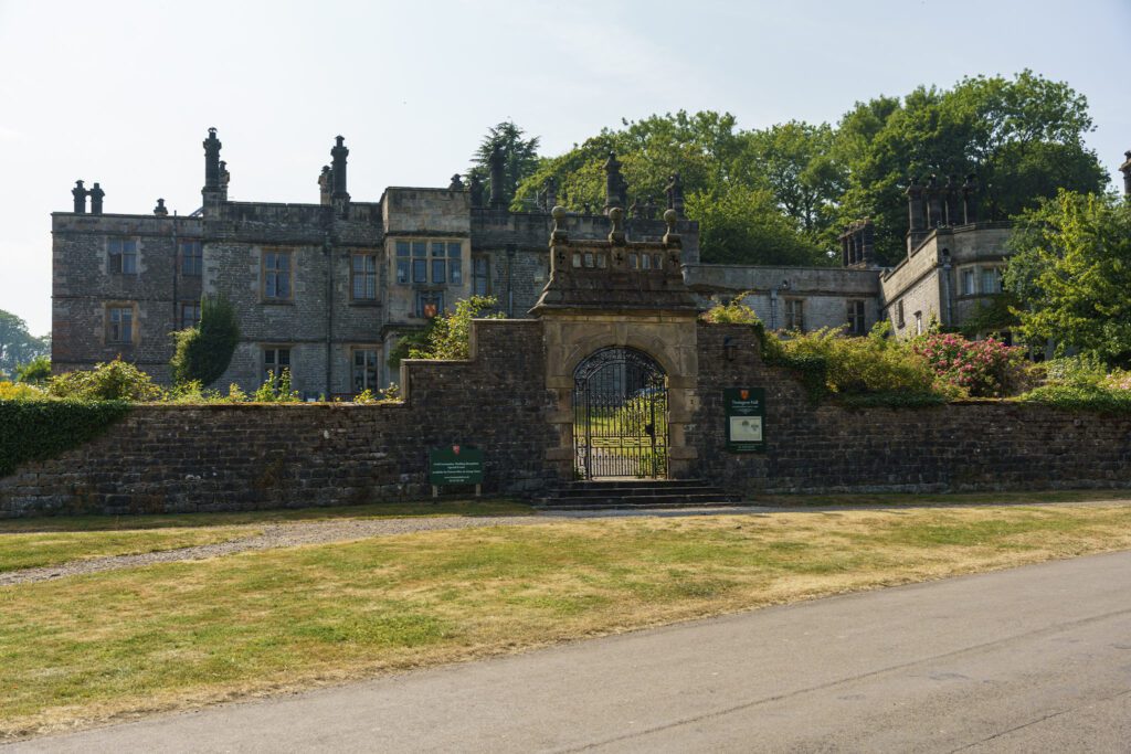 Tissington Hall behind grand stone wall and gates