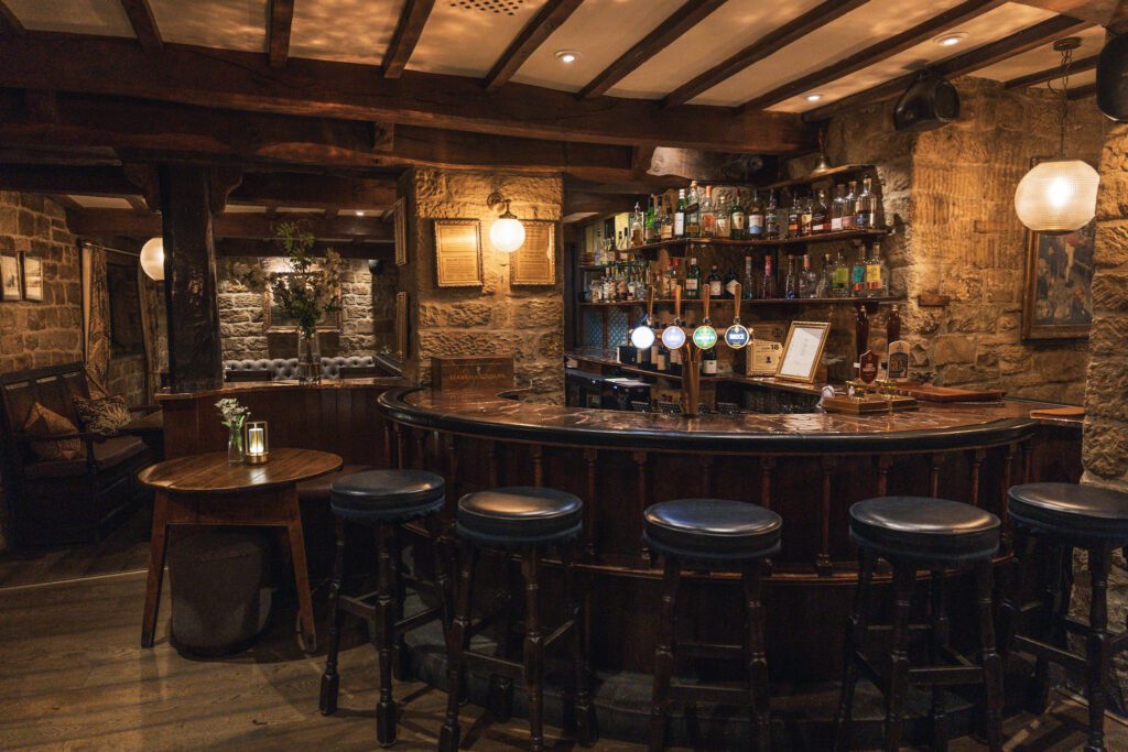 Grade 2 listed copper bar area with drinks on the shelves, bar stools and seating in the far corner