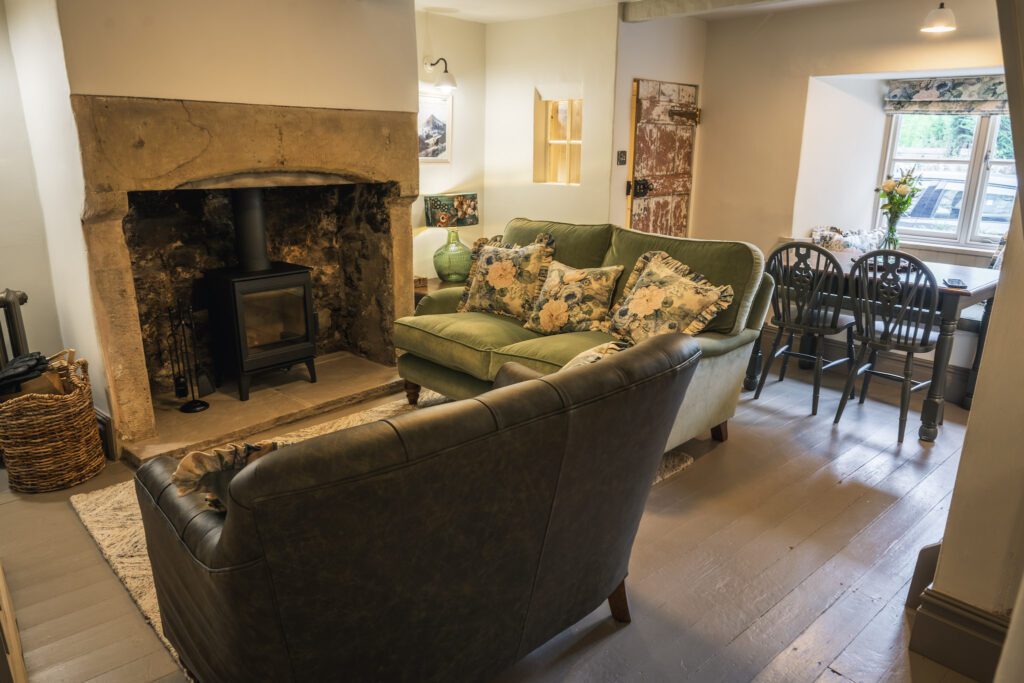 Country cottage cosy living room with hard wood flooring and a log fore with stone surround