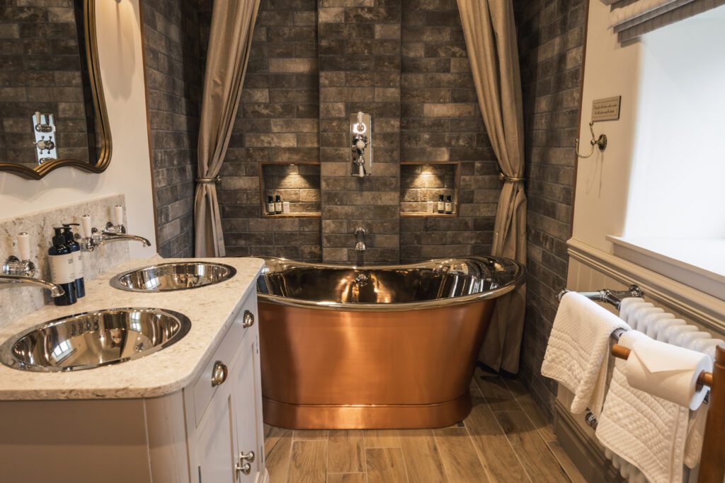 Cottage bathroom with copper freestanding bath, shower overl and double sink