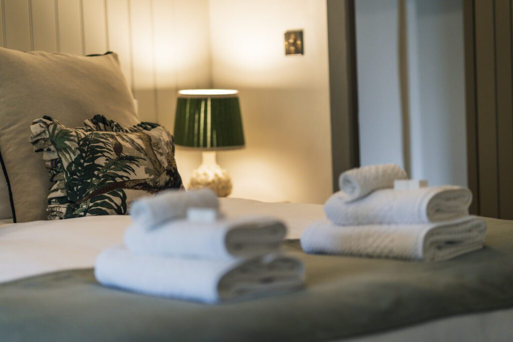 King size bed with cosy bedding, lots of cushions and big fluffy towels