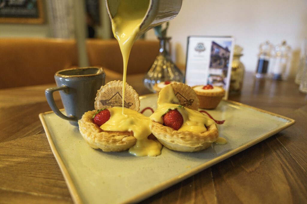 Pouring custard on Bakewell tarts