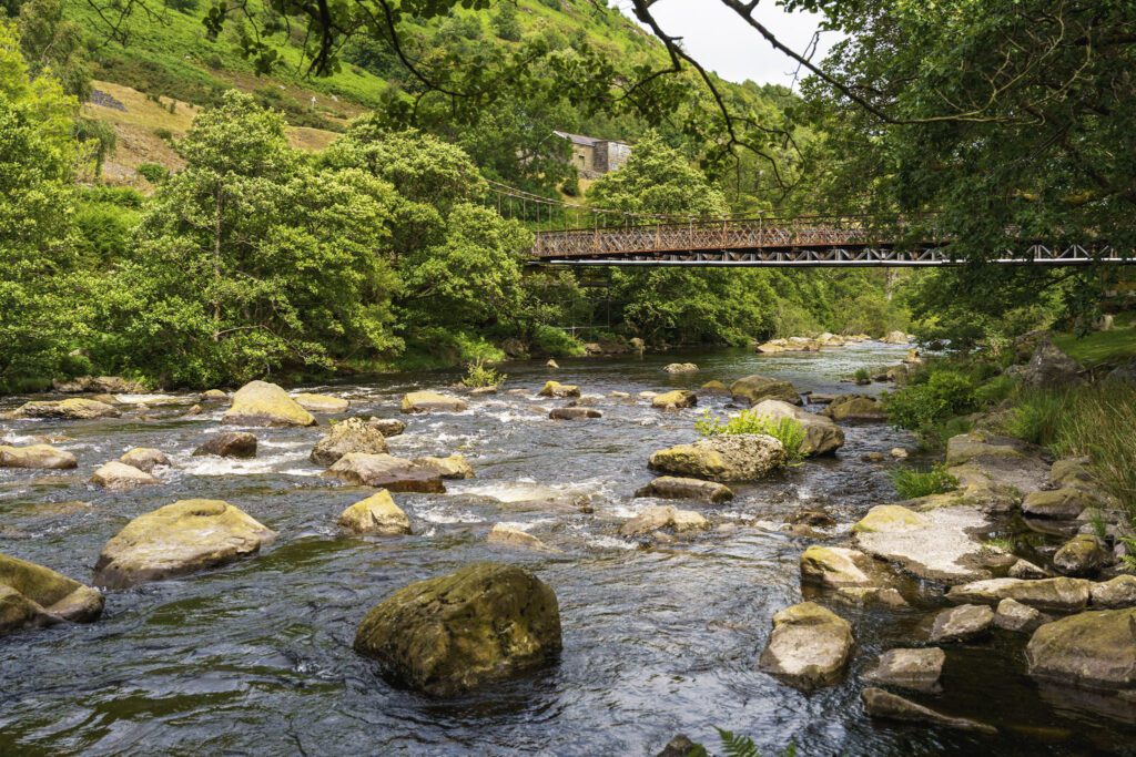 Old bridge over shallow river near Caban Coch Dam