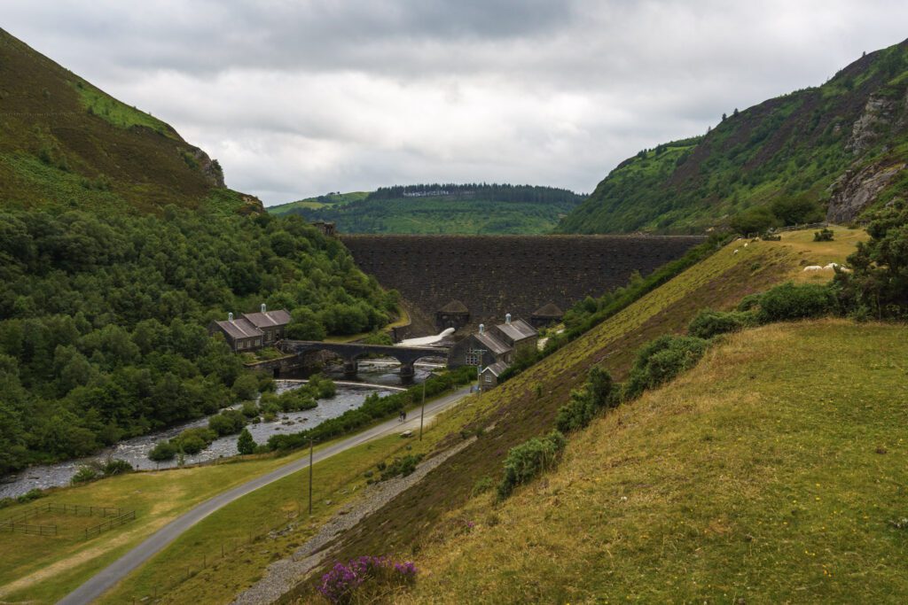 View towards Caban Coch Dam with bridge below and reservoir buildings