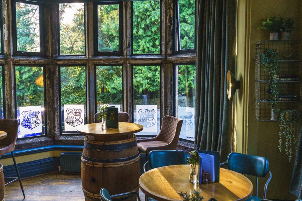 The bar area at The Maynard, Oak barrel tables. leather seating and rustic interior