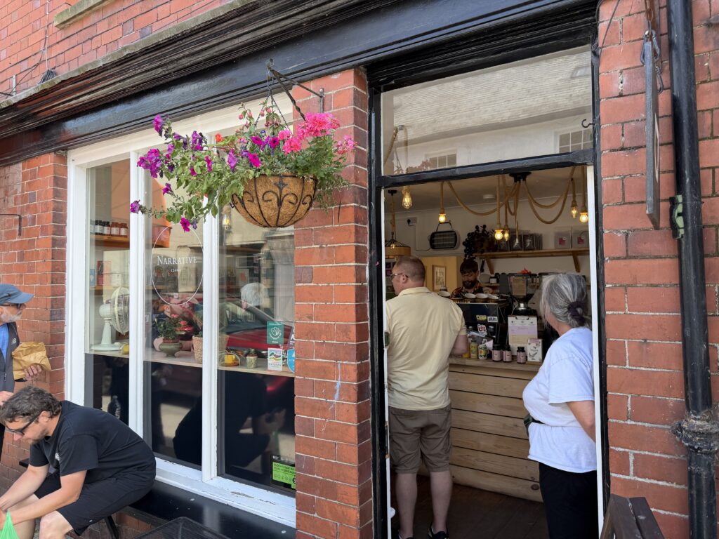 A busy narrative coffee shop exterior looking in