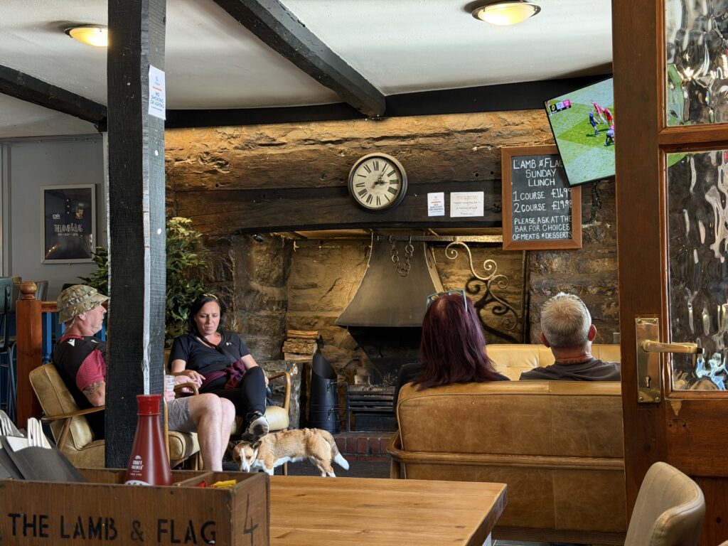 Lamb and Flag fireplace with people sat watching the rugby