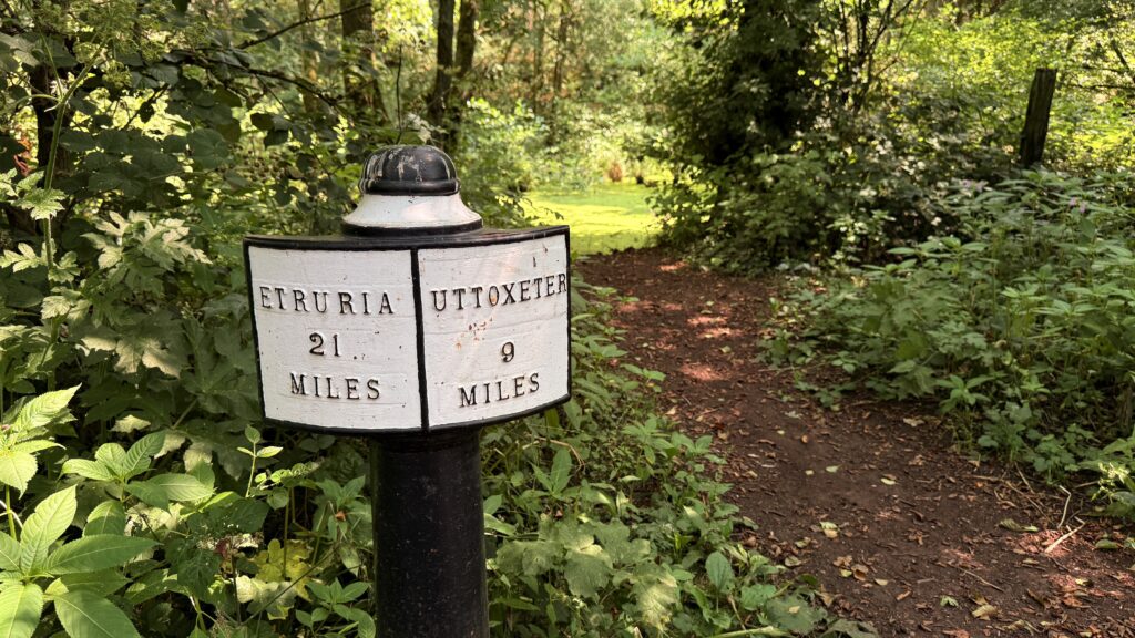 An old milepost reading Etruria 21 miles and Uttoxeter 9 miles beside the path on the Chained Oak walk.