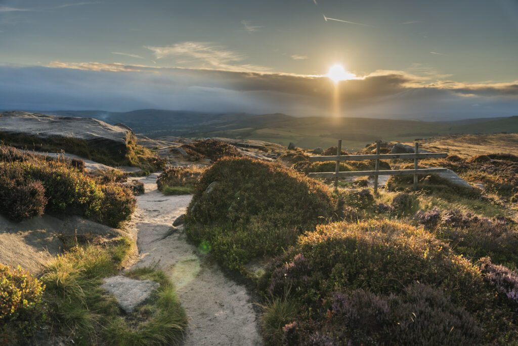 Golden glow and moody skies as the sun sets on Stanage Edge