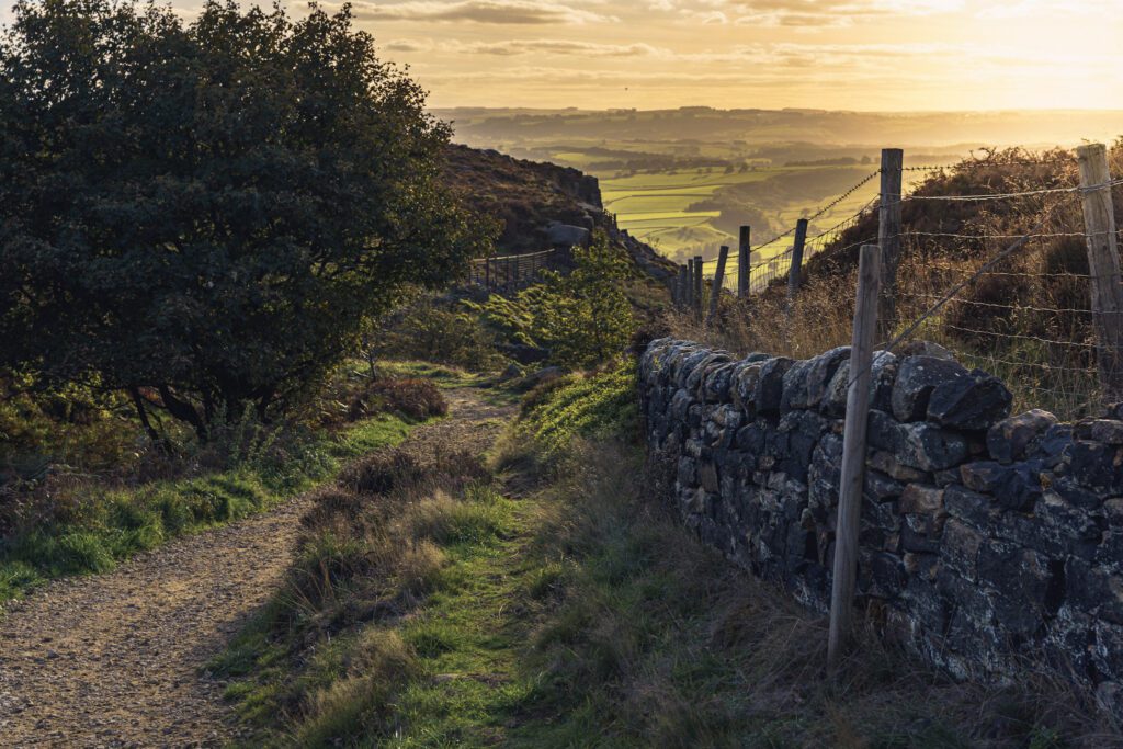 Sunset sky at the end of a dry stone walled path on Curbar edge